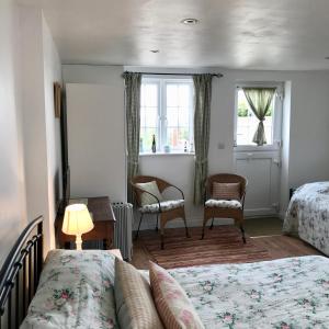 a bedroom with two beds and a table and two chairs at Jago Cottage in Truro