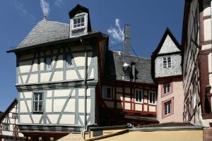 a white building with a clock tower on top at Hotel zum Riesen in Miltenberg