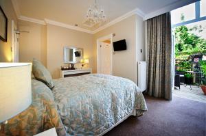 1 dormitorio con 1 cama, TV y ventana en Cheshire Hospitality Ltd Trading As Lennox Lea Studios and Apartments en Sale
