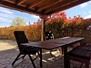 a wooden table and two chairs under a pergola at Rural Badaguas in Jaca