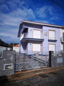 uma casa com uma cerca em frente em Blue Tex em Vila Chã