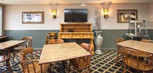 a dining room with tables and a flat screen tv at Tombstone Grand Hotel, a Baymont by Wyndham in Tombstone