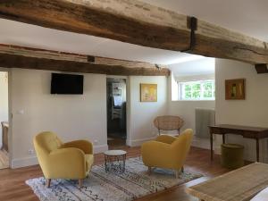 a living room with yellow chairs and a table at L'evidence in Bragny-sur-Saône