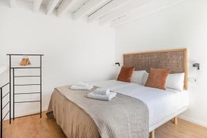 Postel nebo postele na pokoji v ubytování Slow Suites Maestranza