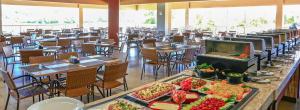 um restaurante com mesas e cadeiras com comida em exposição em ILHAS DO LAGO ECO RESORT em Caldas Novas