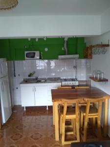- une cuisine avec une table en bois et un mur vert dans l'établissement Dpto Mitre Bariloche, à San Carlos de Bariloche