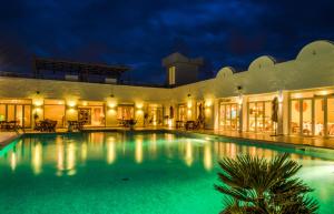 una gran piscina en un edificio por la noche en Les Jardins de Toumana, en Triffa