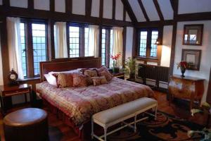 a bedroom with a large bed in a room with windows at The Castle at Skylands Manor in Ringwood