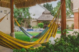 a couple of hammocks in front of a house at Casa Frida Cozumel in Cozumel