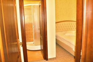 a small bedroom with a bed and a shower at Hotel Crisalpin in Poiana Brasov
