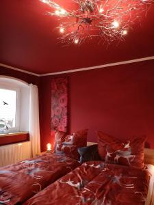 a red bedroom with a bed and a chandelier at Apartment (4 Dinkel) in Hargelsberg