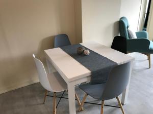 a dining room table with chairs and a white table at appartement Charles Baudelaire in Honfleur