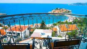a balcony with a table and chairs and the ocean at Villa Edelweiss in Sveti Stefan