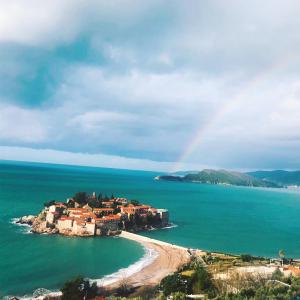 um arco-íris sobre uma pequena ilha no oceano em Villa Edelweiss na Ilha Sveti Stefan