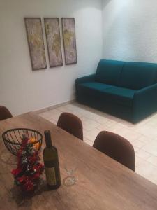 una camera con tavolo, bottiglia di vino e divano blu di Villa Edelweiss a Sveti Stefan
