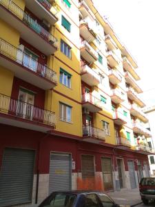 ein gelbes und rotes Gebäude mit vorne geparkt in der Unterkunft Blue Rose Private Room in Salerno