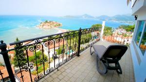 a balcony with a table and a view of the ocean at Villa Edelweiss in Sveti Stefan