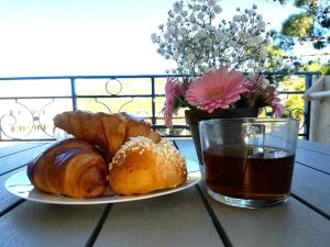 a plate of croissants and a cup of coffee on a table at Appartement piscine mer montagne in Les Issambres