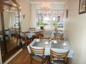 a dining room with tables and chairs and windows at Altstadt Hotel Rheinblick in Düsseldorf
