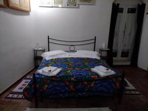 B&B En Suite في ماتيرا: غرفة نوم مع سرير مع لحاف جميل