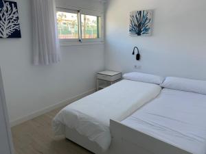 ティアスにあるTeiga Playaの白いベッドルーム(ベッド2台、窓付)