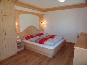 a bedroom with a bed with red pillows on it at Apartments Rit in La Valle