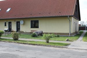 ein gelbes Haus mit rotem Dach auf einer Straße in der Unterkunft Großer Stein in Gevezin