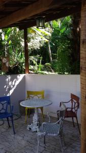 eine Terrasse mit einem Tisch und 4 Stühlen in der Unterkunft Toca da Onça in Penedo
