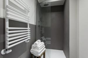 a bathroom with white towels and a glass shower at Charming flat Righi Bologna in Bologna