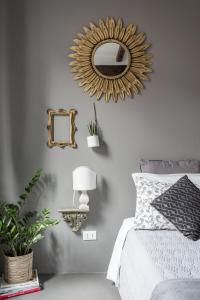 a bedroom with a bed with a mirror and a lamp at Charming flat Righi Bologna in Bologna