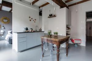 Charming flat Righi Bologna في بولونيا: مطبخ بجدران بيضاء وطاولة خشبية