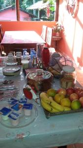 una mesa con manzanas plátanos y otros alimentos en ella en Toca da Onça en Penedo