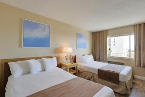 una camera d'albergo con due letti e una finestra di The Beachview Inn Clearwater Beach a Clearwater Beach