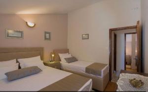 um quarto de hotel com duas camas e um espelho em Apartmani Asanović em Budva