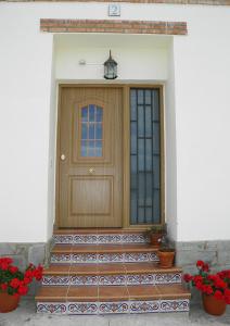 Torrelles的住宿－Casa Rural del Aire Torrellas TarazonaMoncayo，鲜花盛开的房子的前门