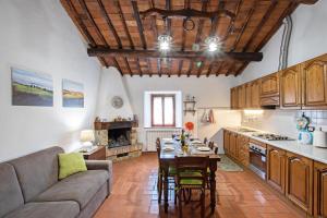 a kitchen and living room with a table and a couch at Agriturismo Il Poderuccio in Castiglione dʼOrcia