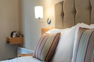 a bedroom with a bed with two pillows and a lamp at The Parsonage Hotel & Spa in Escrick