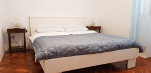Apartments Milica في أوماغ: سرير في غرفة مع اثنين من nighthands وسرير sidx six