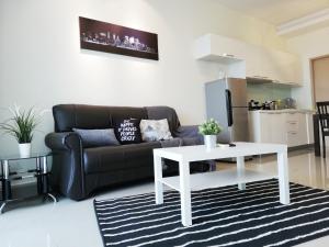 a living room with a couch and a table at Ara Damansara Oasis Residence, Specious Home 4-8pax, 8min Subang Airport, 10min Sunway in Petaling Jaya