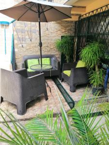 a patio with chairs and a table and an umbrella at Casa Leon Guesthouse in San José
