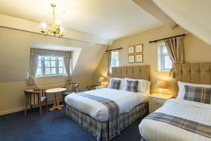 a bedroom with two beds and a table and chairs at The Parsonage Hotel & Spa in Escrick