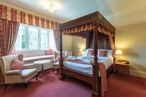 a bedroom with a canopy bed and a chair at The Parsonage Hotel & Spa in York +127 photos