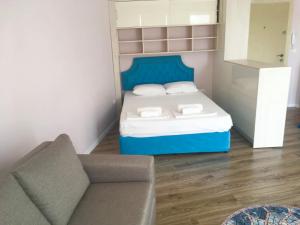 a small bedroom with a bed and a couch at Bluemarine Apartment in Sofia
