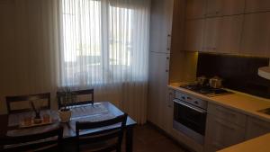 a kitchen with a table and a kitchen with a stove at Gardino Apartamentai in Šiauliai