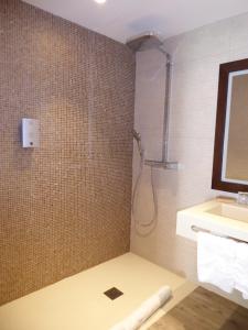 uma casa de banho com um chuveiro e um lavatório. em Hôtel Kastell Dinec'h em Minihy-Tréguier