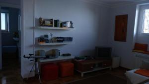 a room with a table and a television and shelves at Lekeitio Paraiso in Lekeitio