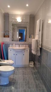 a bathroom with a toilet and a sink and a mirror at Lekeitio Paraiso in Lekeitio