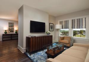 a living room with a couch and a tv at Belleview Inn in Belleair