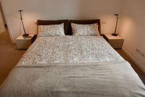 een slaapkamer met een groot bed met twee nachtkastjes bij Stylish Lakefront House in Lovere