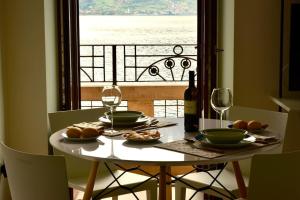 una mesa con platos de comida y copas de vino y una ventana en Stylish Lakefront House en Lovere